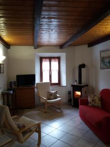 a living room with a red couch and a fireplace at Appartamento La Volpe in Pian degli Ontani