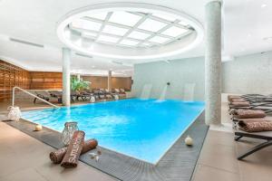 una piscina en una habitación de hotel con equipo de béisbol en Sumus Hotel Stella & Spa 4*Superior, en Pineda de Mar