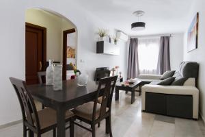 una sala da pranzo e un soggiorno con tavolo e divano. di Apartamentos El Tajo & SPA a Ronda