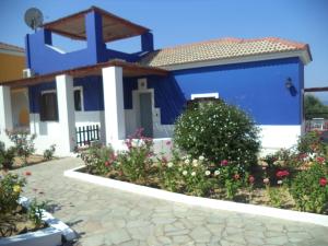 a blue and white house with flowers in front of it at Ilis Villas in Kyllini