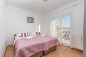 斯塔布魯克的住宿－Apartment La Mare，一间卧室配有一张带粉色床单的床和一扇窗户。
