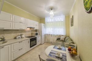 a kitchen with white cabinets and a table and a couch at 1 Поверх ж к Паркові Озера метро Дарниця институт Серця МВЦ in Kyiv +25 photos