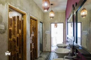 a bathroom with three sinks and two mirrors at The Explorers Guesthouse and Hostel in Kuala Lumpur