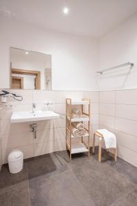 La salle de bains est pourvue d'un lavabo et d'une étagère avec des serviettes. dans l'établissement Apart Auszeit, à Niederthai