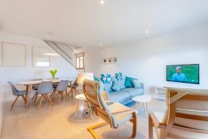 - un salon avec un canapé bleu et une table dans l'établissement Beachfront Villa Socias Playa, à Playa de Muro