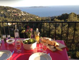 una mesa con un plato de comida y vistas al océano en Villa Simone en Carqueiranne