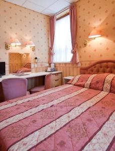 a bedroom with two beds and a desk and a mirror at White Heather Hotel in Llandudno