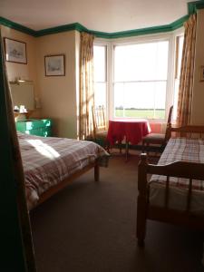 A bed or beds in a room at Homelea Guest House 