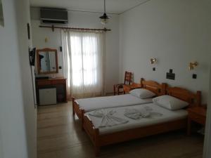 1 dormitorio con 2 camas y espejo en Rania Beach, en Iräon