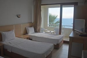 a hotel room with two beds and a view of the ocean at Dikelya Hotel in Dikili