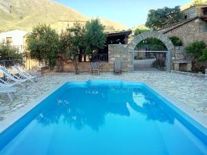 une grande piscine bleue dans une cour dans l'établissement Baglio Poma, à Castelluzzo
