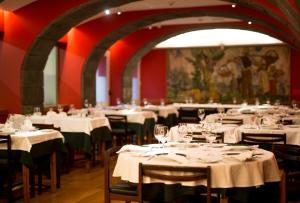 a dining room with white tables and chairs at Hotel Alcides in Ponta Delgada