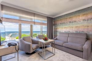 a living room with a couch and a table at Hotel Aurora Family & SPA in Międzyzdroje