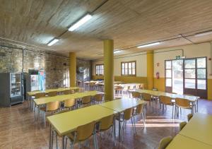 une salle de classe avec des tables et des chaises jaunes dans un bâtiment dans l'établissement Albergue Inturjoven Cortes De La Frontera, à Cortes de la Frontera