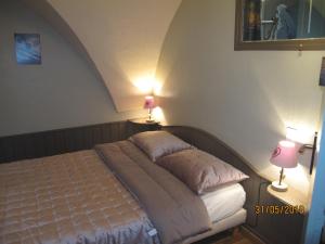 een bed in een slaapkamer met 2 lampen aan de muur bij La Rose des Vents in Saint-Bonnet-en-Champsaur