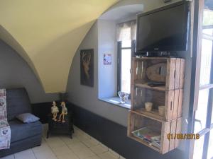 a living room with a flat screen tv on a wall at La Rose des Vents in Saint-Bonnet-en-Champsaur