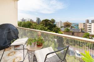 uma varanda com duas cadeiras e uma mesa com plantas em Home with a View with Pool and Roof Terrace Garden em Sidney