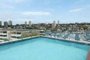 a large swimming pool with a view of a city at Home with a View with Pool and Roof Terrace Garden in Sydney