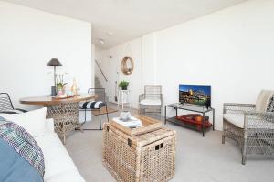 uma sala de estar com um sofá, cadeiras e uma mesa em Home with a View with Pool and Roof Terrace Garden em Sidney