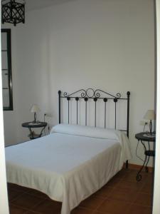 a bed in a bedroom with two nightstands and two tables at Mirador de Jabuguillo in Aracena