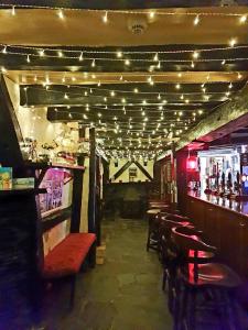 un bar con una fila de sillas y luces en Jolly Sailor Inn en Looe