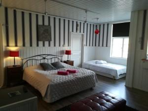 1 dormitorio con 2 camas en una habitación con paredes a rayas en Hotelli Huiskankorpi Boutique Hotel, en Nivala