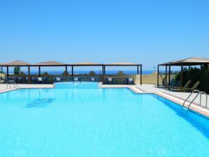 a large swimming pool with blue water at Telhinis Hotel & Apartments in Faliraki
