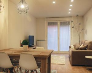 a living room with a wooden table and a couch at Apartamento Erdi Kale in Azpeitia