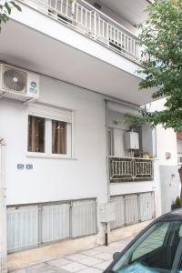 - un bâtiment blanc avec un balcon et une voiture garée devant dans l'établissement City House Apartment, à Thessalonique