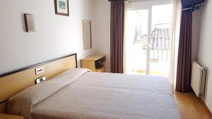 a bedroom with a bed and a large window at Hotel La Cala in Roses