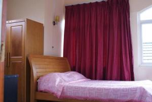 a bedroom with a bed and a red curtain at Villa Les Aigrettes in Mahébourg