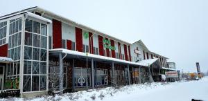 um edifício com neve no chão à sua frente em Hotel Tuulonen em Tuulos