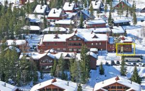 a ski lodge with snow on the roofs of buildings at Sjumilskogen in Trysil