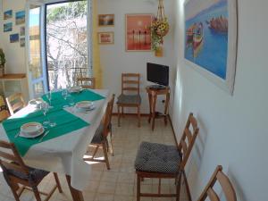 una sala da pranzo con tavolo, sedie e TV di Il Gelso a Marina di Castagneto Carducci