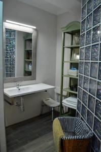 un bagno con un lavandino, uno specchio e una sedia di El Patio De La Aljama a Cordoba