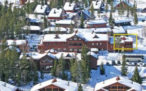 a ski lodge with snow on the roofs of buildings at Sjumilskogen in Trysil +2 photos