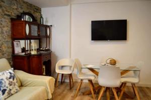 salon ze stołem, krzesłami i telewizorem w obiekcie El Patio De La Aljama w Kordobie