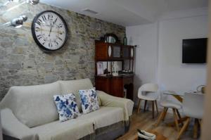 un soggiorno con un divano e un orologio a parete di El Patio De La Aljama a Cordoba