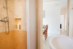 een badkamer met een bad, een wastafel en een douche bij Le Gioie - Dimora Scalelle - Villetta con giardino e veranda vista mare in Torre Vado