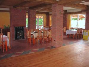a dining room with tables and chairs and a fireplace at Siedlisko Agroturystyczne in Mrągowo
