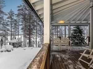 HavumäkiにあるHoliday Home Eemilin huvila by Interhomeの雪の中のベンチ付屋根付きポーチ
