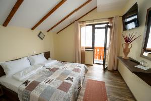 a bedroom with a bed and a tv and a window at Casa Bucatarului in Bălnaca