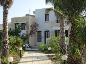 a white house with palm trees in front of it at Apartments Seagull in Kos