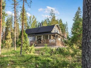 HavumäkiにあるHoliday Home Eemilin huvila by Interhomeの森の黒屋根の家