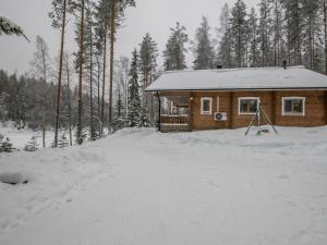 a log cabin in the snow in a forest at Holiday Home Salmensuu by Interhome in Havumäki