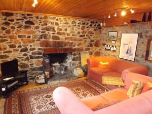 TarskavaigにあるHoliday Home Tarskavaig by Interhomeのソファと石造りの暖炉のあるリビングルーム