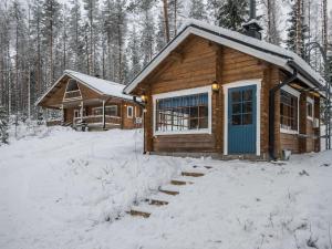 HavumäkiにあるHoliday Home Salmensuu by Interhomeの雪の中に青いドアが付いたログキャビン