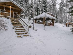une cabane en rondins avec un kiosque dans la neige dans l'établissement Holiday Home Mäntyrinne by Interhome, à Havumäki