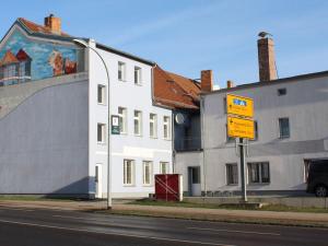 ein Straßenschild vor einem weißen Gebäude in der Unterkunft Pension BERLIN in Spremberg in Spremberg