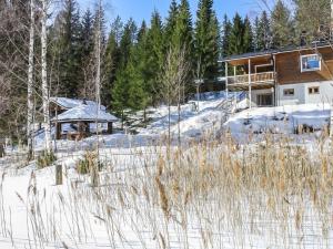 HavumäkiにあるHoliday Home Mäntyrinne by Interhomeの雪の中の木々の丸太小屋